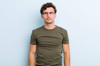 Genç ve yakışıklı adam kafası karışmış görünüyor, merak ediyor ya da bir sorunu çözmeye çalışıyor ya da düşünüyor.