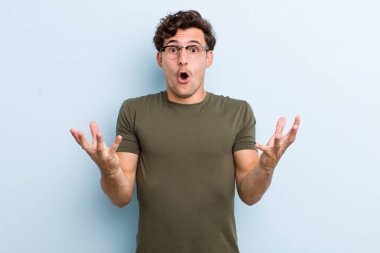 Genç, yakışıklı, ağzı açık ve şaşkın, şok olmuş ve şaşırmış bir adam.