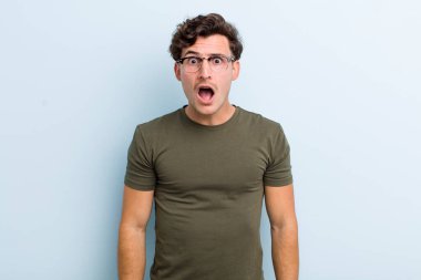 Şok olmuş, kızgın, sinirli ya da hayal kırıklığına uğramış, ağzı açık ve öfkeli genç bir adam.