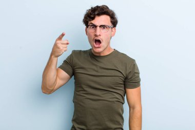 Genç yakışıklı bir adam kızgın agresif bir ifadeyle kameraya bakıyor. Öfkeli, çılgın bir patron gibi görünüyor.