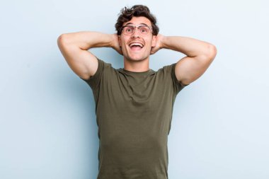 Genç yakışıklı adam mutlu, kaygısız, arkadaş canlısı ve rahat görünüyor. Hayattan ve başarıdan keyif alıyor, olumlu bir tavırla.