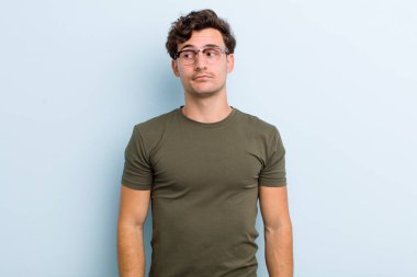 Genç yakışıklı adam merak ediyor, mutlu düşünceler ve fikirler düşünüyor, hayal kuruyor, kenarda yer arıyor.