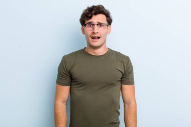 Genç yakışıklı adam korkmuş ve şok olmuş hissediyor, ağzı açık şaşkınlık içinde.