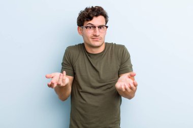 Genç yakışıklı bir adam bilgisiz ve kafası karışık, hangi seçeneği seçeceğinden emin değil, merak ediyor.