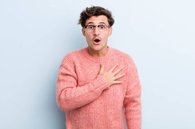 Genç yakışıklı adam şok olmuş ve şaşırmış hissediyor, gülümsüyor, el ele tutuşuyor, o olmaktan mutlu ya da minnettarlık gösteriyor.