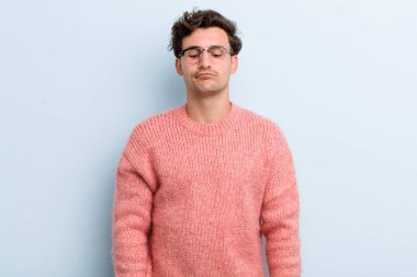 Genç ve yakışıklı adam şapşal ve komik görünüyor. Şaşı bakışlı, şakacı ve şakacı.