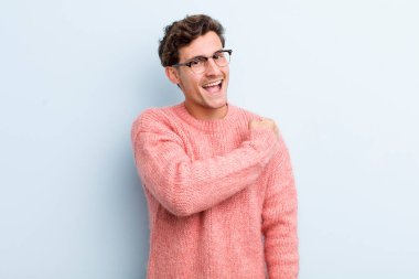 Genç yakışıklı adam mutlu, pozitif ve başarılı hissediyor, bir meydan okumayla karşılaştığında motive oluyor veya iyi sonuçları kutluyor.