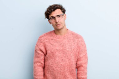 Genç yakışıklı adam şaşkın ve şaşkın hissediyor, aptal, afallamış bir ifadeyle beklenmedik bir şeye bakıyor.