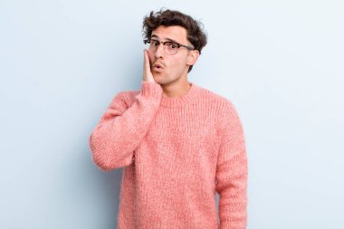 Genç yakışıklı adam şok olmuş ve ağzı açık halde yüz yüze inanamamaktan şaşkına dönmüş durumda.