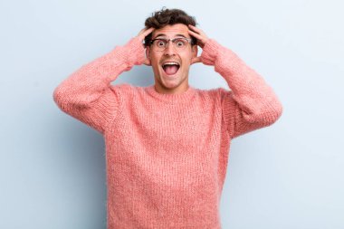 Genç yakışıklı adam el ele tutuşuyor, ağzı açık, son derece şanslı, şaşırmış, heyecanlı ve mutlu hissediyor.