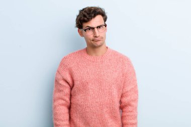 Genç yakışıklı, kafası karışık ve şüpheli hissediyor, merak ediyor ya da karar vermeye çalışıyor.