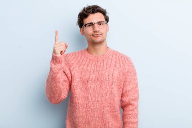 Genç yakışıklı bir adam, harika bir fikri fark ettikten sonra parmağını havaya kaldırıp 