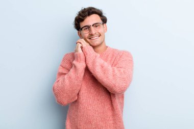 Genç, yakışıklı bir adam aşık ve sevimli görünüyor. Sevimli ve mutlu. Romantik bir şekilde gülümsüyor.