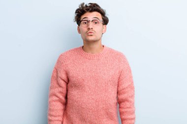 Genç yakışıklı adam dudaklarını birbirine bastırıyor, tatlı, eğlenceli, mutlu, sevimli bir yüz ifadesiyle, öpücük yolluyor.