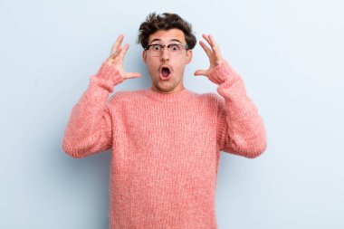 Genç yakışıklı adam elleri havada bağırıyor, öfkeli, sinirli, stresli ve üzgün hissediyor.