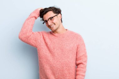 Genç yakışıklı adam neşeyle ve tesadüfen gülümsüyor, olumlu, mutlu ve kendinden emin bir bakışla göğüs göğüse.