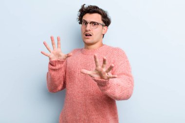 Dehşete kapılmış genç yakışıklı bir adam korku ve panik içinde geri çekiliyor ve bir kabusa tepki veriyor.