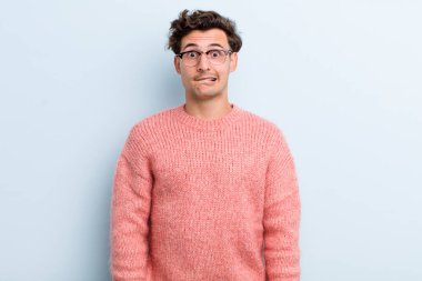 Genç yakışıklı adam kendini cahil, kafası karışmış ve hangi seçeneği seçeceği konusunda kararsız hissediyor, sorunu çözmeye çalışıyor.