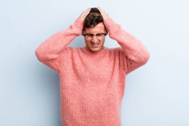 Genç ve yakışıklı bir adam stresli ve hayal kırıklığına uğramış hissediyor. Yumruk yumruğa, yorgun, mutsuz ve migren ağrısı çekiyor.