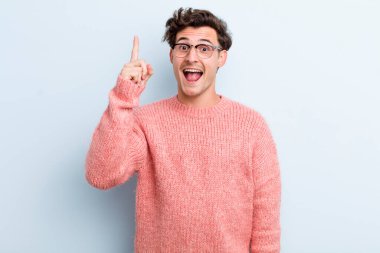 Genç yakışıklı bir adam bir fikri fark ettikten sonra mutlu ve heyecanlı bir dahi gibi hissediyor, neşeli bir şekilde parmağını kaldırıyor, eureka!