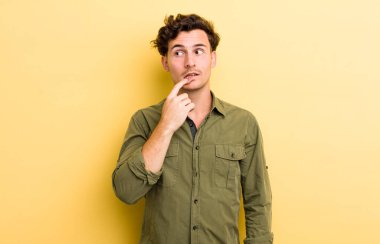 Şaşırmış, gergin, endişeli ya da korkmuş bakışları olan genç yakışıklı bir adam kopya boşluğuna bakıyor.