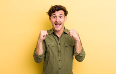 Genç yakışıklı adam şok olmuş, heyecanlı ve mutlu, gülüyor ve başarıyı kutluyor, vay canına diyor.!