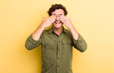 Genç yakışıklı adam gülümsüyor ve mutlu hissediyor, iki eliyle gözlerini kapatıyor ve inanılmaz bir sürpriz bekliyor.