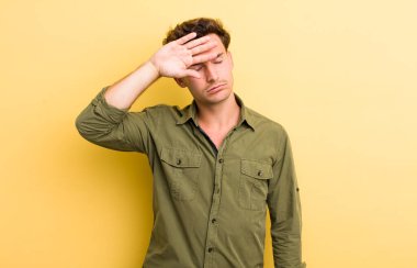 Genç yakışıklı adam stresli, yorgun ve hayal kırıklığına uğramış, alnından ter damlayan, umutsuz ve bitkin hisseden.