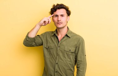 Genç yakışıklı, kafası karışmış ve kafası karışmış hissediyor. Deli, deli ya da aklını kaçırmış olduğunu gösteriyor.