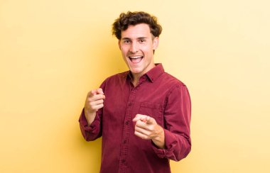 Genç yakışıklı adam kendini mutlu, havalı, tatmin olmuş, rahat ve başarılı hissediyor, kameraya bakıyor, seni seçiyor.