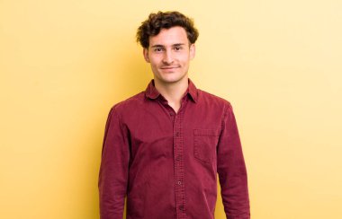 Genç yakışıklı, gururlu, kendinden emin, havalı, küstah, küstah, gülümseyen, başarılı hisseden bir adam.