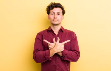 Şaşkın, kafası karışmış, güvensiz ve şüpheyle zıt yönlere bakan genç yakışıklı bir adam.