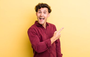 Genç ve yakışıklı bir adam heyecanlı ve şaşırmış görünüyor.