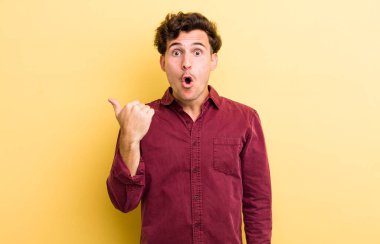 Genç ve yakışıklı adam inançsızlıktan şaşkın şaşkın bakıyor, yan taraftaki objeyi işaret ediyor ve diyor ki vay canına, inanılmaz.