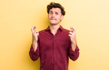 Genç yakışıklı adam endişeyle dua ediyor ve endişeli bir bakışla iyi şanslar diliyor.