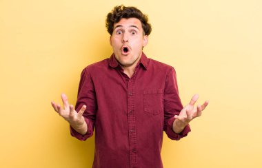 Genç, yakışıklı, ağzı açık ve şaşkın, şok olmuş ve şaşırmış bir adam.