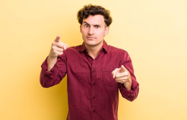 Genç ve yakışıklı bir adam kameraya hem parmaklarını hem de kızgın yüzünü göstererek sana görevini yapmanı söylüyor.