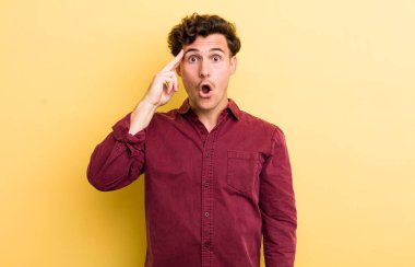 Genç yakışıklı adam şaşırmış, ağzı açık, şok olmuş, yeni bir düşünce, fikir ya da konsept keşfediyor.