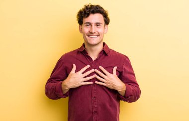 Genç yakışıklı adam mutlu görünüyor, şaşırmış, gururlu ve heyecanlı, kendini gösteriyor.