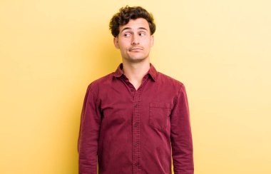 Genç yakışıklı adam merak ediyor, mutlu düşünceler ve fikirler düşünüyor, hayal kuruyor, kenarda yer arıyor.