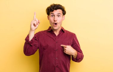 Genç yakışıklı adam gururlu ve şaşırmış, kendine güvenen, kendini bir numara gibi hisseden.