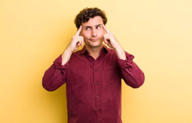 Genç yakışıklı bir adam konsantre olmuş ve bir fikir üzerinde kafa yoruyor, bir meydan okumaya ya da soruna bir çözüm hayal ediyor.