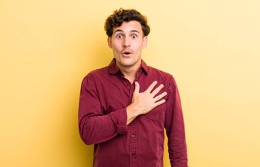 Genç yakışıklı adam şok olmuş ve şaşırmış hissediyor, gülümsüyor, el ele tutuşuyor, o olmaktan mutlu ya da minnettarlık gösteriyor.