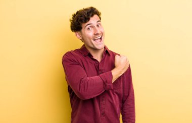 Genç yakışıklı adam mutlu, pozitif ve başarılı hissediyor, bir meydan okumayla karşılaştığında motive oluyor veya iyi sonuçları kutluyor.