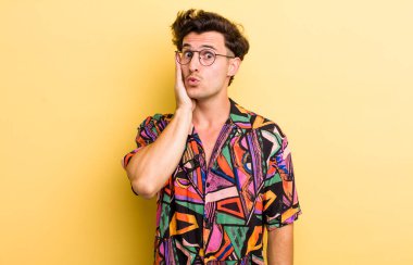 Genç yakışıklı adam şok olmuş ve ağzı açık halde yüz yüze inanamamaktan şaşkına dönmüş durumda.