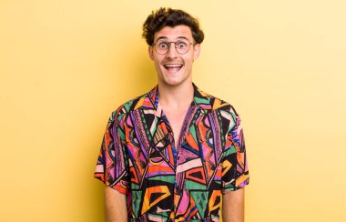 Genç yakışıklı adam mutlu ve hoş bir şekilde şaşırmış görünüyor. Büyülenmiş ve şok olmuş bir ifadeyle heyecanlanıyor.