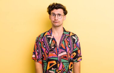 Genç yakışıklı, kafası karışık ve şüpheli hissediyor, merak ediyor ya da karar vermeye çalışıyor.