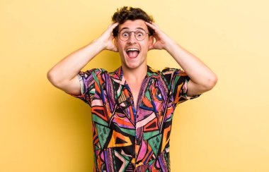 Genç yakışıklı adam el ele tutuşuyor, ağzı açık, son derece şanslı, şaşırmış, heyecanlı ve mutlu hissediyor.