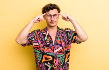 Ciddi ve konsantre görünümlü, beyin fırtınası yapan ve zorlu bir sorunu düşünen genç yakışıklı bir adam.