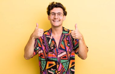 Genç yakışıklı adam gülümsüyor. Mutlu, pozitif, kendinden emin ve başarılı görünüyor.